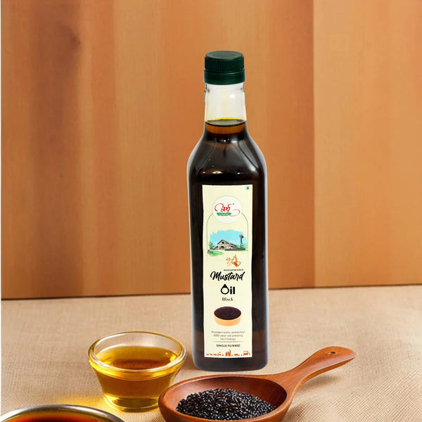 A bottle of Woodpressed Black Mustard Oil displayed alongside a small wooden bowl filled with black mustard seeds and a glass bowl with a small amount of oil.