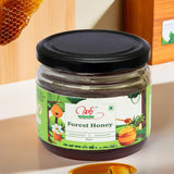 A jar of Pure Wild Forest Honey with a label that includes an illustration of a honeycomb and a bee. The jar is placed on a wooden surface.