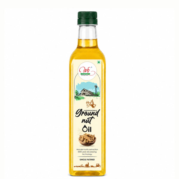 Bottle of groundnut oil with a green cap on a white background